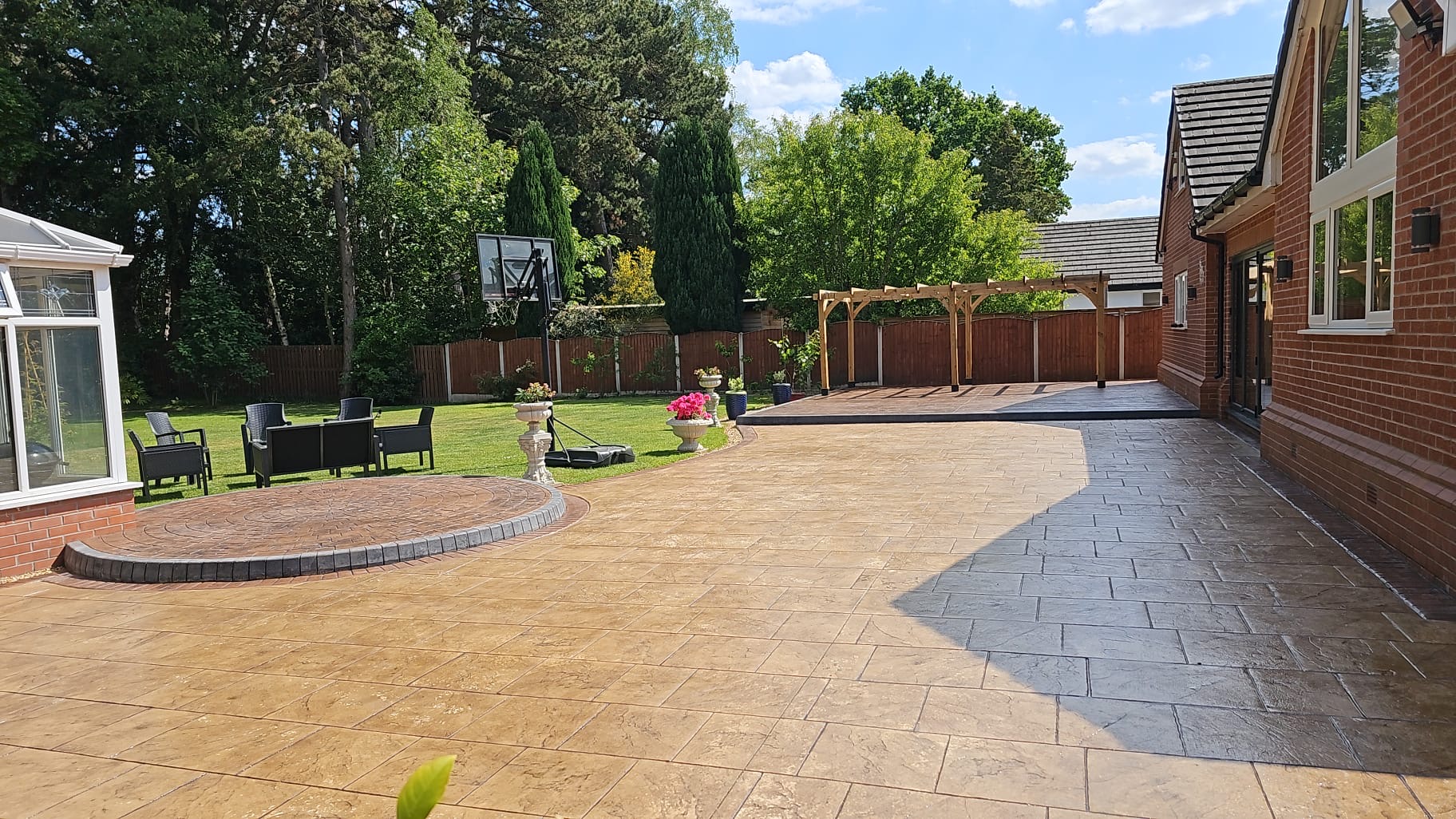 A stunning concrete patio with raised concrete decking and feature concrete dial in Sale, Manchester