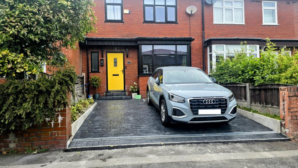 Front garden with concrete driveway conversion and car on it