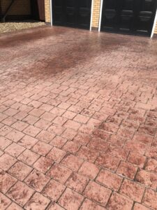 red concrete driveway needing a re-seal, before sealant applied
